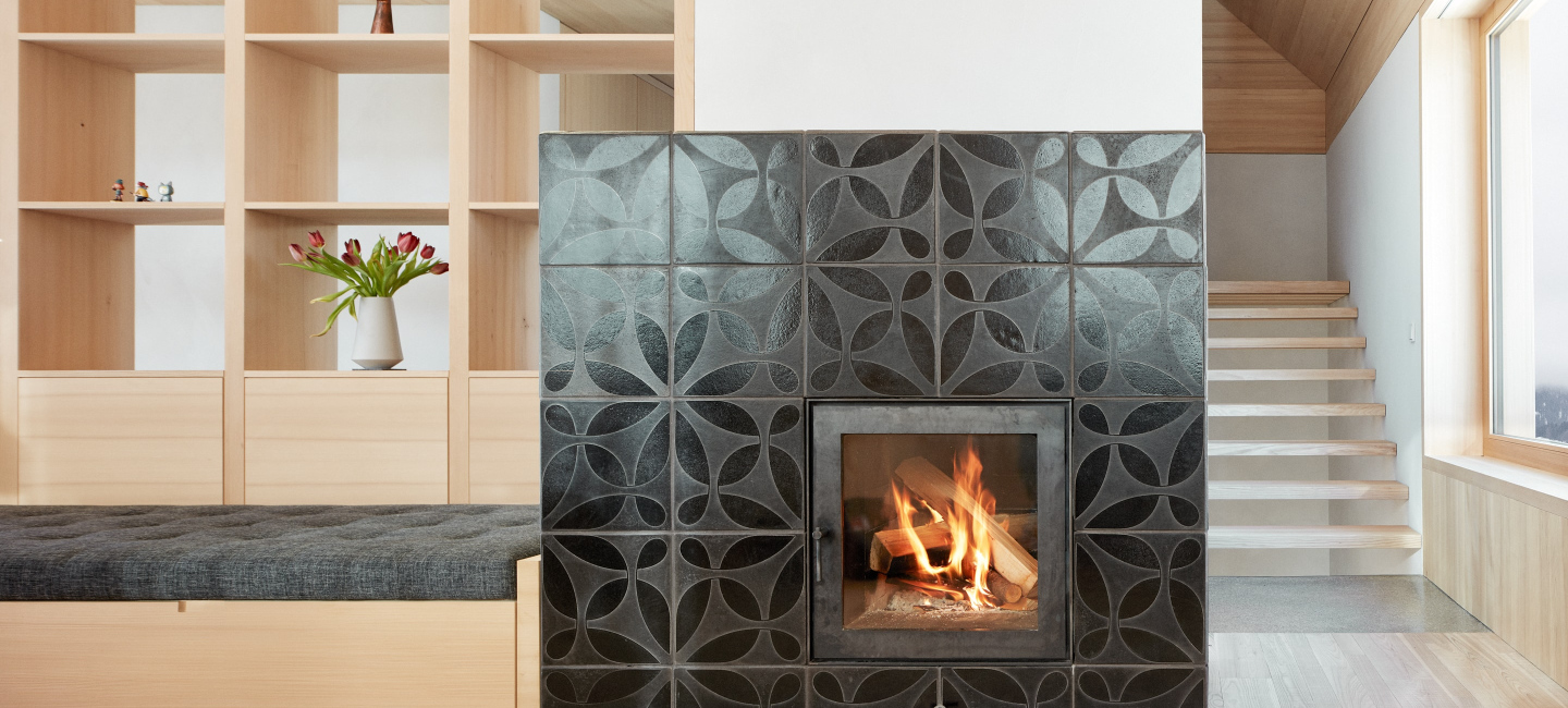 Ofenbau Voppichler – Grundofen aus Egg im Bregenzerwald, 3,5 kW Heizleistung, verkleidet mit KARAK Raku-Fliesen, Schwarzstahl und Schamotte.