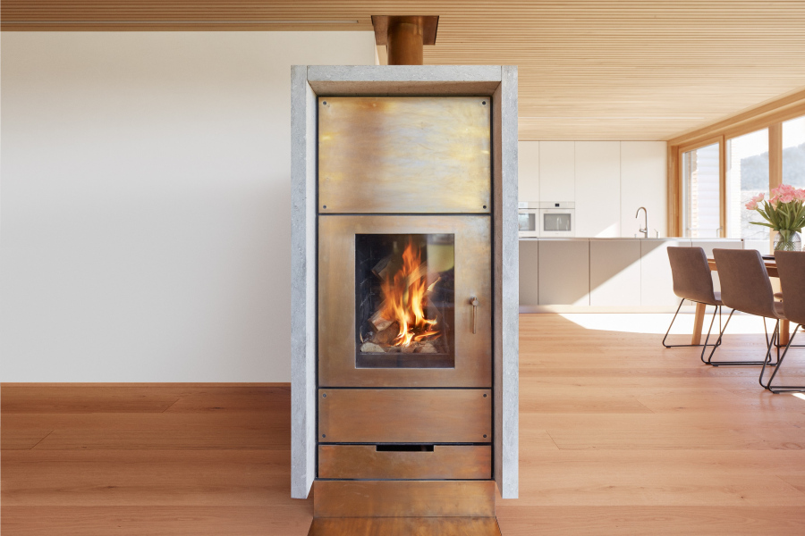 Ofenbau Voppichler – Speicherofen mit stilvoller Kombination aus Kalkstein und brüniertem Messing.