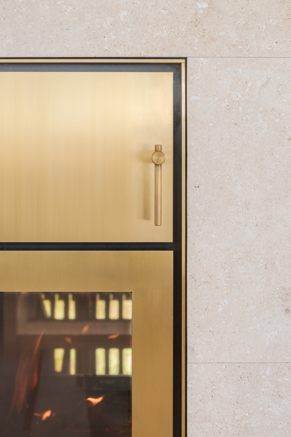 Speicherofen aus Kalkstein Avorio beige mit Messing und Schamotte, 3,5 kW, 12h Heizzeit – Ofenbau Voppichler, Egg Bregenzerwald.